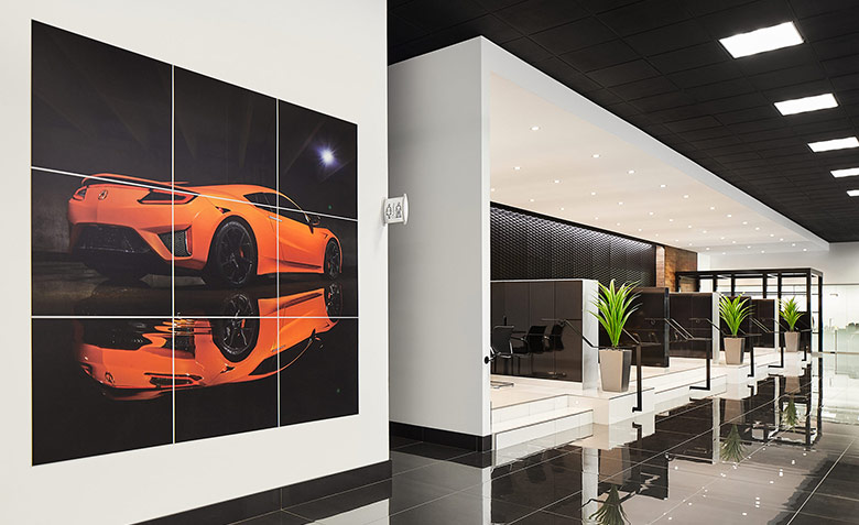 Poster d'une voiture orange sur un mur et bureaux de ventes